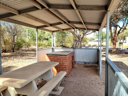 Concrete seating and public barbeque under verandah