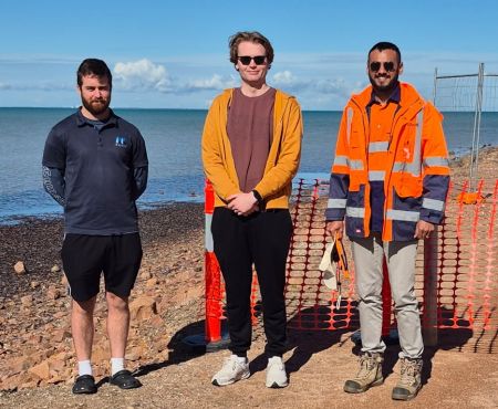 Three workers representing Sproutt and Magryn standing in front of barrier mesh.