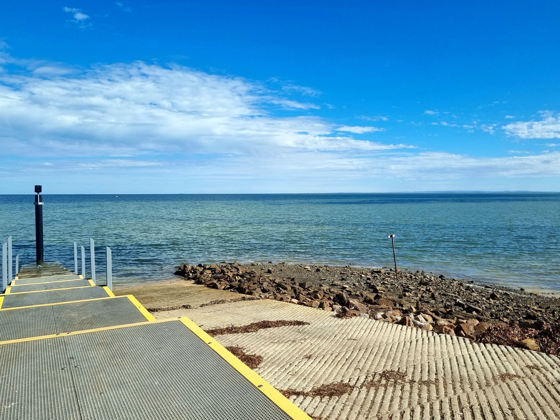 Concrete boat ramp with stepped walkway.