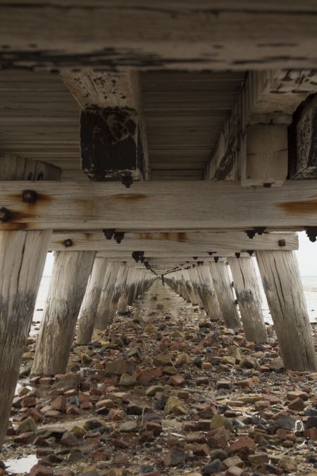 View under Port Germein Jetty, rocky ground fading into sand.