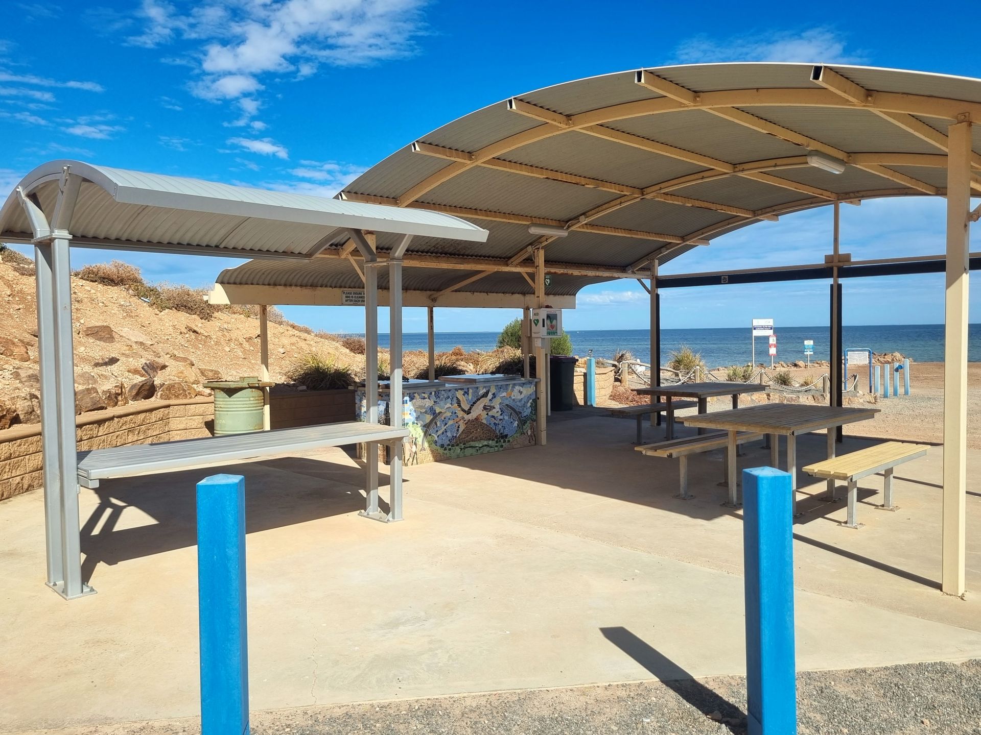 Sheltered seating at Weeroona Island Boat Ramp with ocean set behind.
